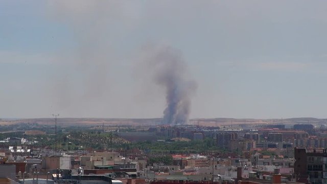 great grey intense smoke fire in outskirt of Madrid city, Spain, from far
