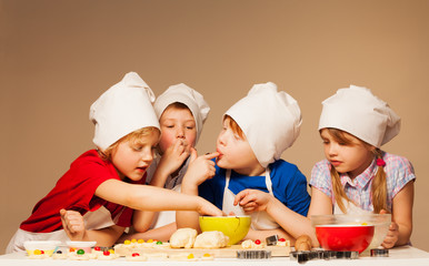 Cute kids tasting dough for handmade cookies