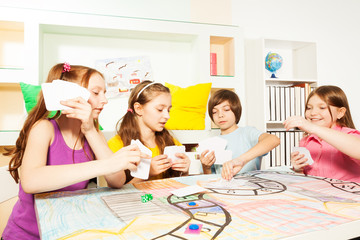 Four friends playing the tabletop game with cards