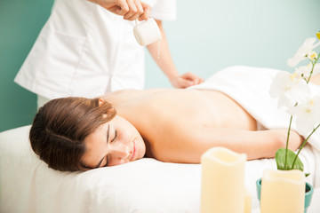 Obraz na płótnie Canvas Getting a candle massage at the spa