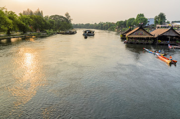 Obraz premium High angle view from bridge, beautiful landscape of Kwai Yai River at sunset and lifestyle of people on the waterfront in Kanchanaburi Province, Thailand