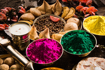 holi festival food with colours, indian festival holi, samosa, kachori, laddu, gujiya, palash flower, thandai, farsan, chana masala, puran poli or roti, indian festival of colours called holi
