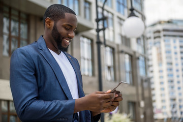 Intelligent African man using telephone outdoors