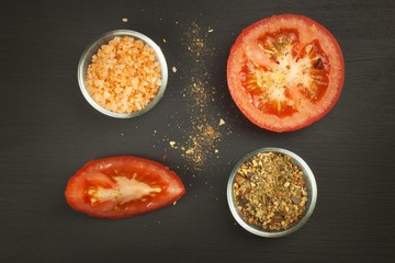 Ripe tomatoes with spices on a wooden board. Growing vegetables.