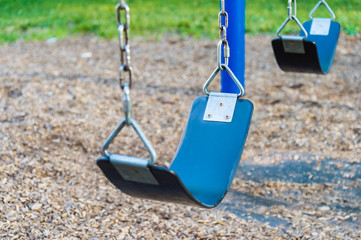 Empty playground blue swing set (selective focus)
