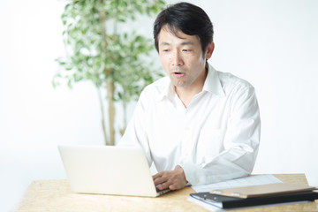 デスクワークするミドル男性