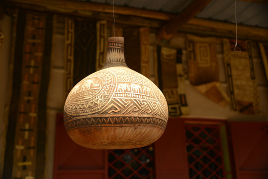 Carved decorative African water gourd hanging on porch