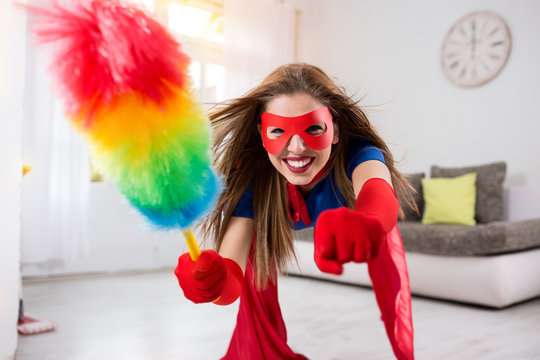Attractive woman superhero flying through the room with a feathe