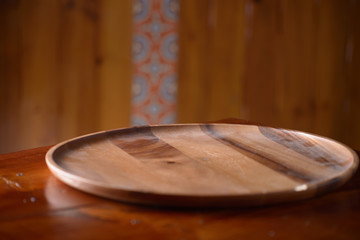 Empty white plate on wooden table over wood background