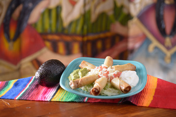 Traditional Mexican food taquito platter with avocado