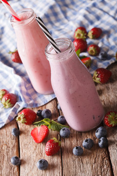 smoothie with strawberries and blueberries in bottles close-up. vertical
