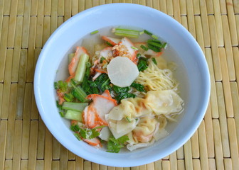 yellow noodle with barbecue pork and dumpling in clear soup on bowl