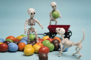 Two skeleton kids getting chocolate candy with red wagon