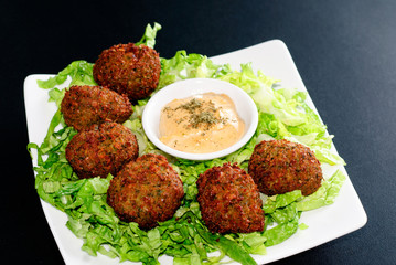 a plate of falafel with hummus dip