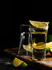 Mexican Gold Tequila with lime and salt on wooden table