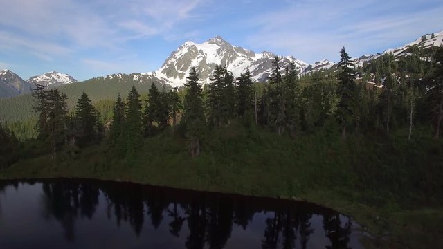 Rising Aerial from Highwood Lake to Reveal Snowy Peaks of Mt Shuksan in Summer