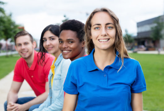 Lachender europäische Frau mit internationalen Freunden