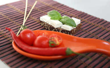 Fresh cherry tomatoes and chili on red