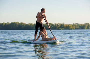 beach fun couple on stand up paddle board SUP02 - obrazy, fototapety, plakaty