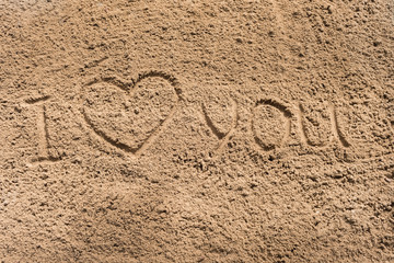 love - an inscription a hand on sea sand