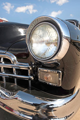 Obraz premium Headlight retro car on background of cloudy sky. Vintage. (Luxur