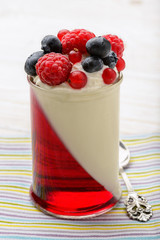Delicious dessert - panna cotta with berry jelly and berries.