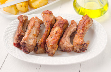 fried pork ribs in white tray on wooden
