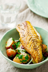 fried mackerel with potatoes in a bowl