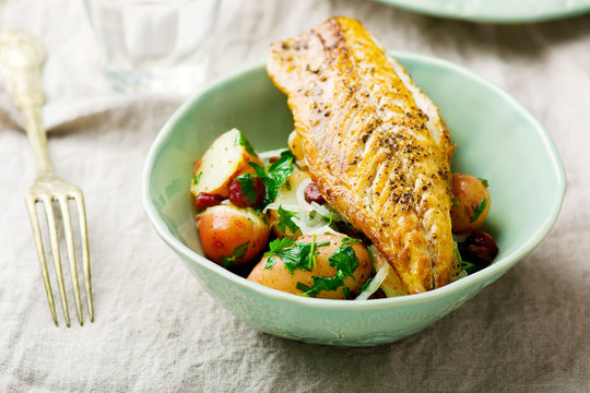 fried mackerel with potatoes in a bowl