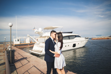 Happy wedding couple hugging near new yacht