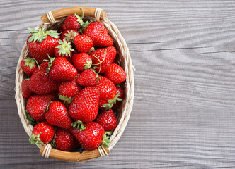 Big strawberry in basket  on wooden background. Close up, top view, high resolution product.