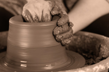 Potter shaping clay on the pottery wheel