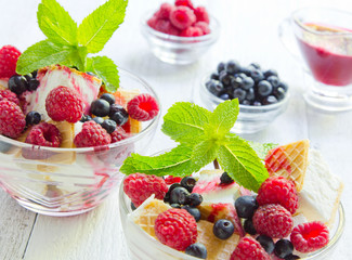 Ice cream with berries and mint. Dessert. White wood background, old board.