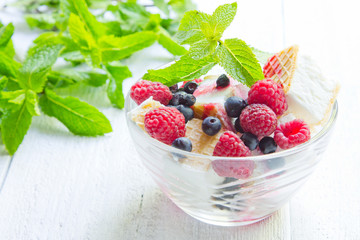 Ice cream with berries and mint. Dessert. White wood background, old board.