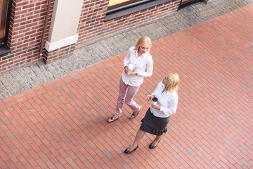 Cheerful mother and daughter going on street