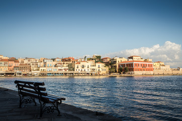 Fototapeta na wymiar View of the old venetian port of Chania on Crete island, Greece. Tourists relaxing on promenade.