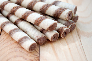 Biscuits wafer rolls on a wooden board