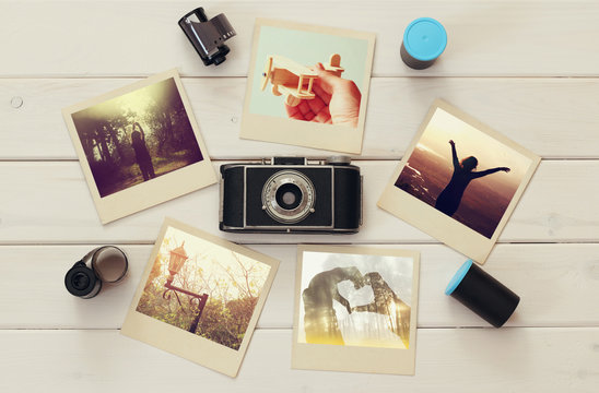 Top view of travel instant photographs next to old camera