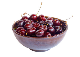 Ceramic bowl of cherries isolated on white. Selective focus