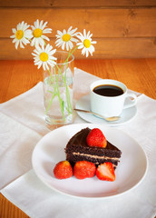 Chocolate cake with fresh strawberry and a cup of coffee