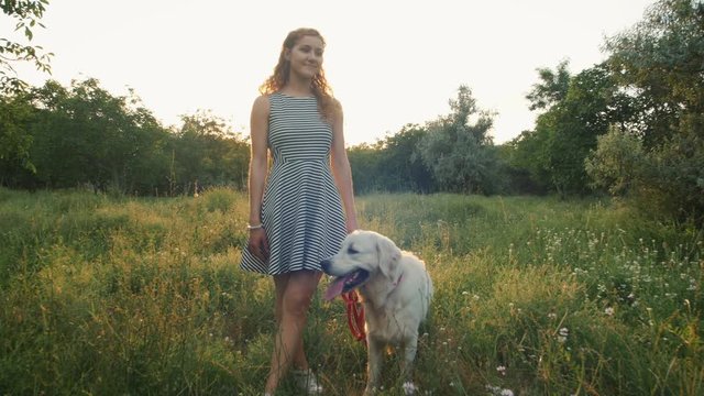 Young woman with retriever dog in park during sunset
