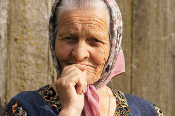 grandmother eighty years old looks forward with his hands to his mouth