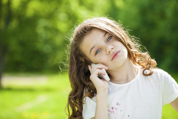 Portrait of a beautiful young little girl calling by phone