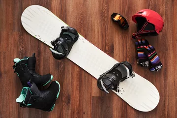 Foto op Canvas set of snowboard boots, helmet, gloves and mask on wooden © Аrtranq