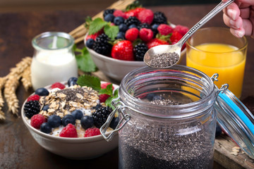 Spoon of chia. Bowl with berries.