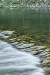 Fototapeta na wymiar Water flowing thrugh the cascade on a stream