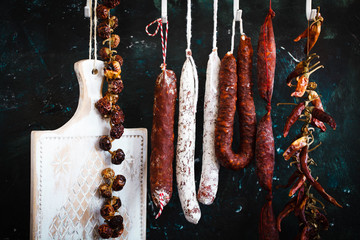 Charcuterie products with dried peppers on hang.