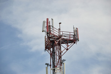 Base transceiver station (BTS) with antenna isolated on blue sky background. Telecommunications radio tower cells 