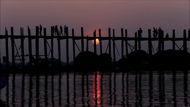 U Bein Bridge at sunset with people crossing Ayeyarwady River, Mandalay, Myanmar