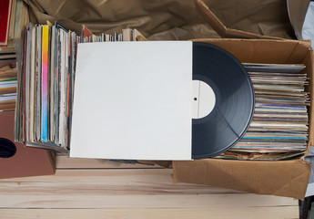 Retro styled image of a collection of old vinyl record lp's with sleeves on a wooden background....